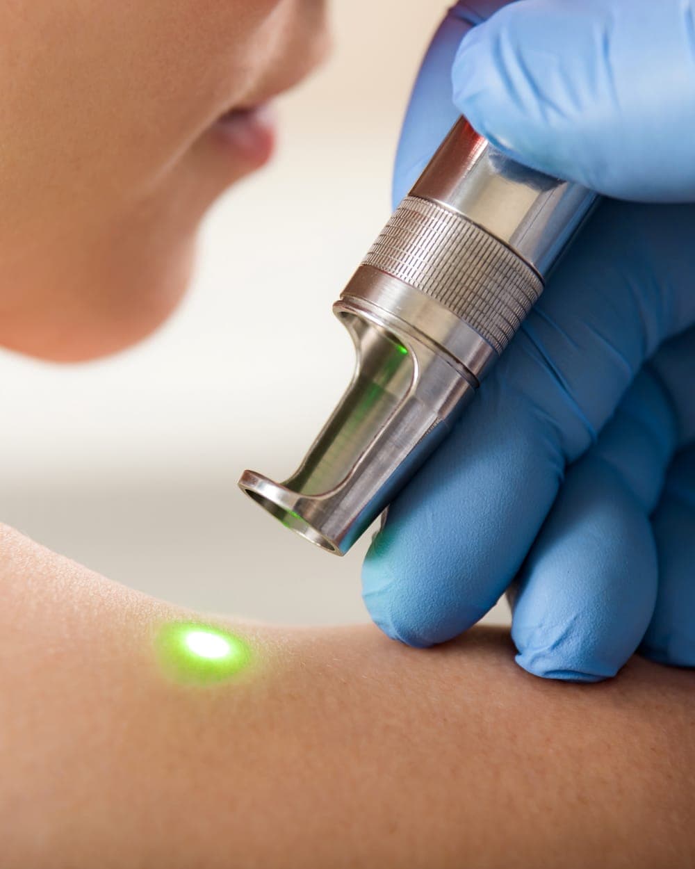 Practitioner using a treatment device on a client's skin