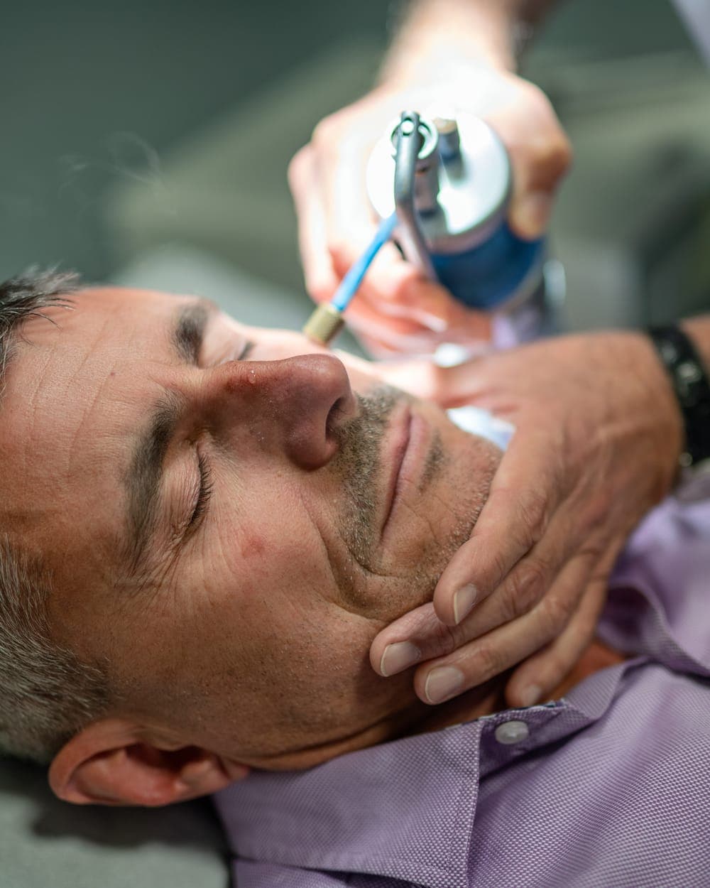Practitioner treating a client's face in clinic