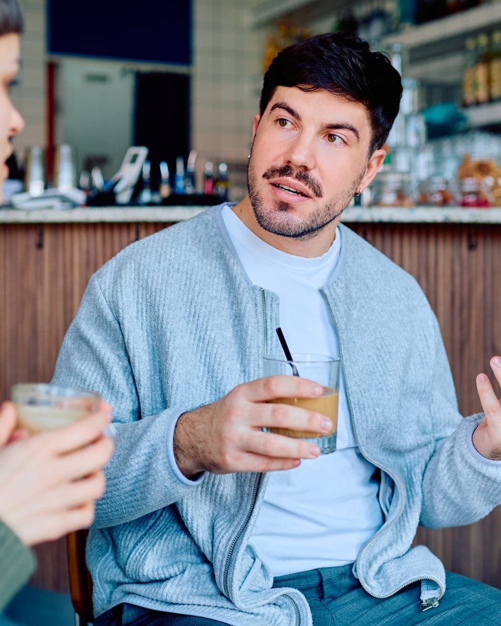 Young man talking with a friend over coffee